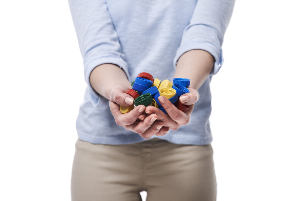 Close up of bottle caps in hands