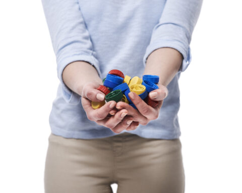 Close up of bottle caps in hands