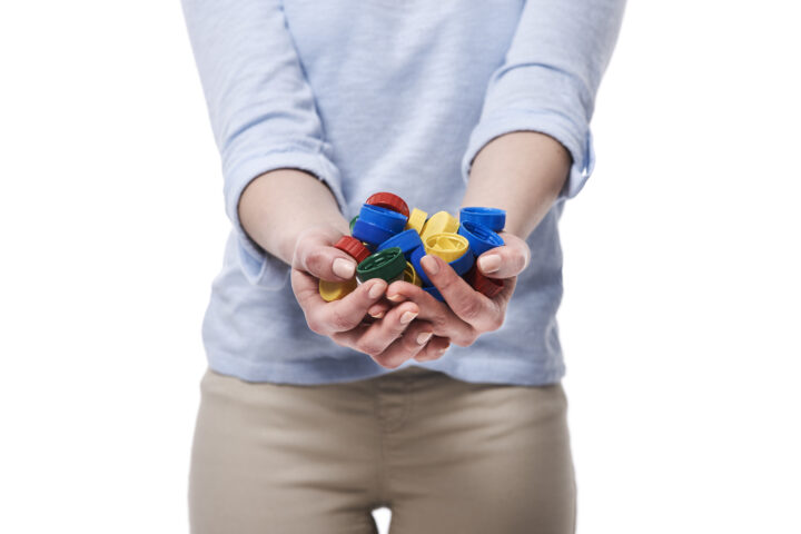 Close up of bottle caps in hands